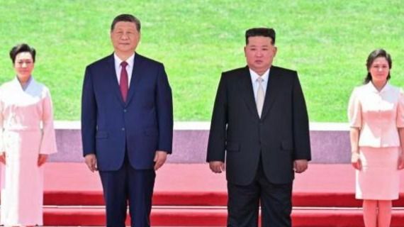 Photograph of Chinese leader Xi Jinping and North Korean leader Kim Jong Un standing formally during a visit